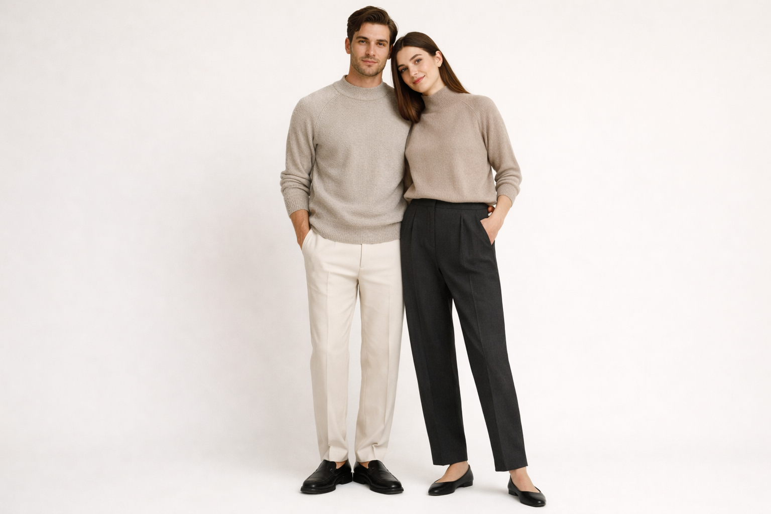 Un homme et une femme complices bras dessus, bras dessous posant pour une photo avec un arriere plan beige unis. Les 2 personnes portent le pull Washi Knit couleur sable de la marque HIKARI
